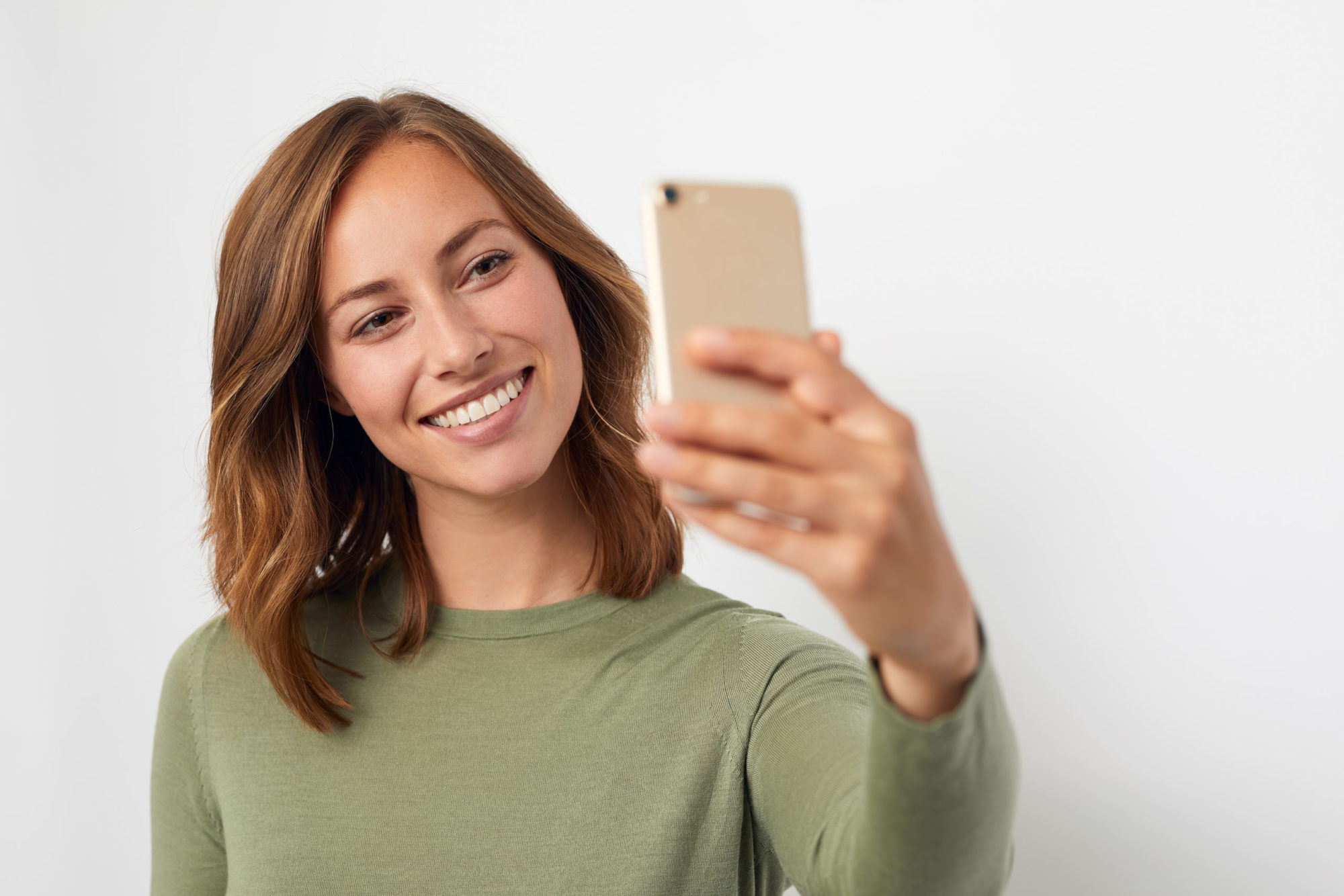 Smiling woman taking a selfie with a confident smile during aligner treatment